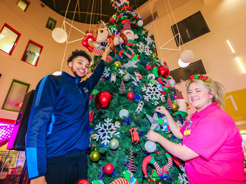 Caledonia Gladiators player Clifton Moore Jr helps Claire Differ decorate the Glasgow Children’s Hospital Christmas tree